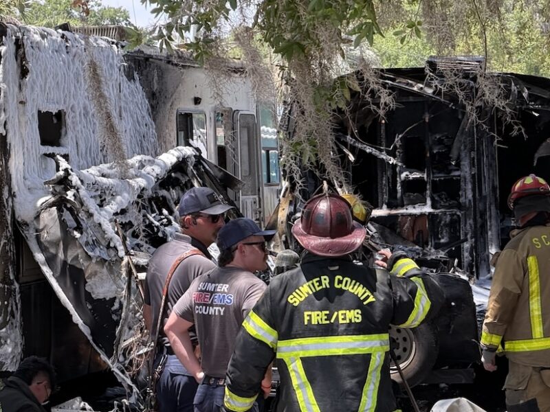 Sumter County Fire EMS first responders exam the RVs which were heavily damaged in the fire.