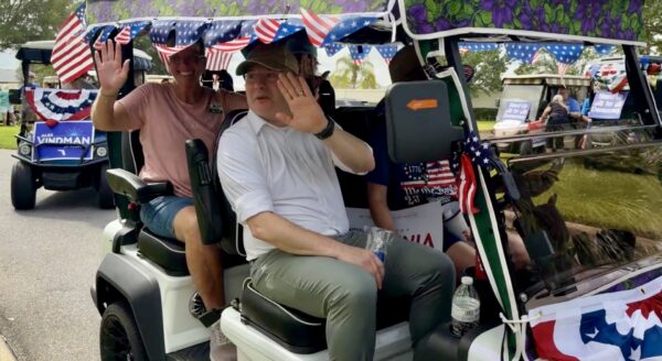 U.S. Senate candidadte Alex Windman waves to the crowd during the golf cart rally