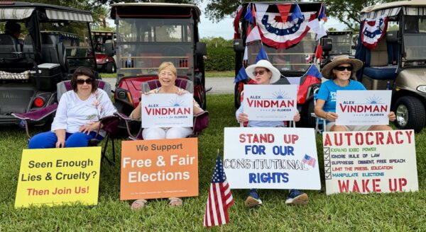 Villagers held signs urging free elections and voting for Alex Vindman as the next Florida senator.