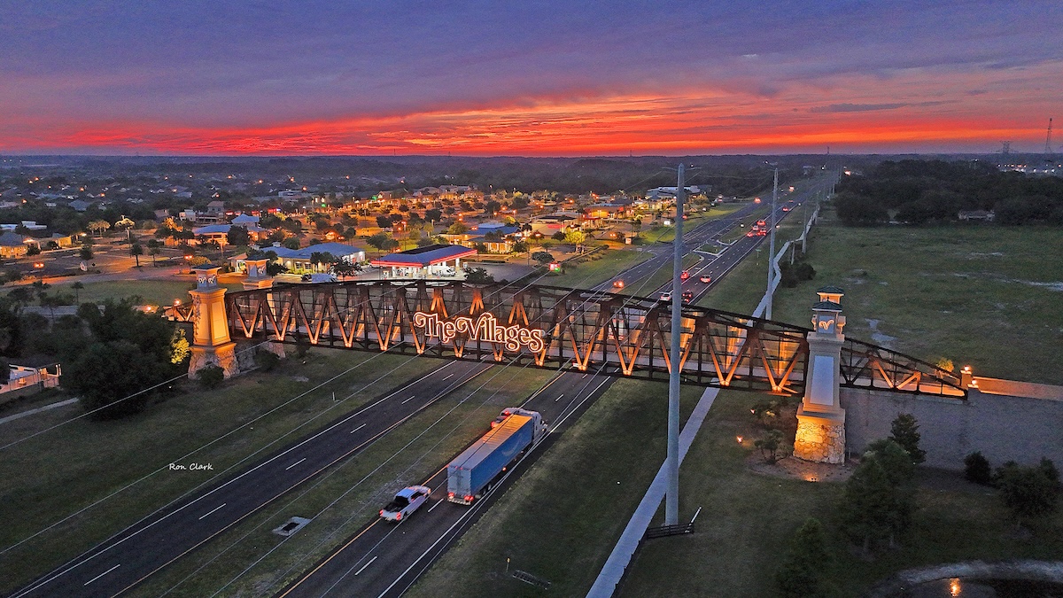Vibrant sunrise colors the sky over the iconic golf cart bridge at Lake Deaton Plaza Vibrant sunrise colors the sky over the iconic golf cart bridge at Lake Deaton Plaza